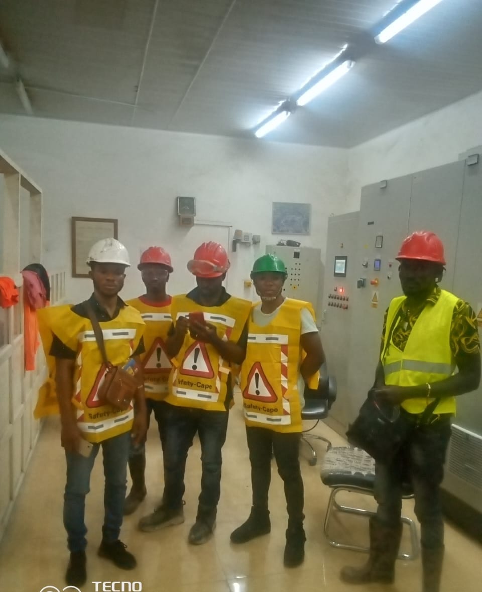 Flogal crew in safety gear beside control-room switchgear during commissioning